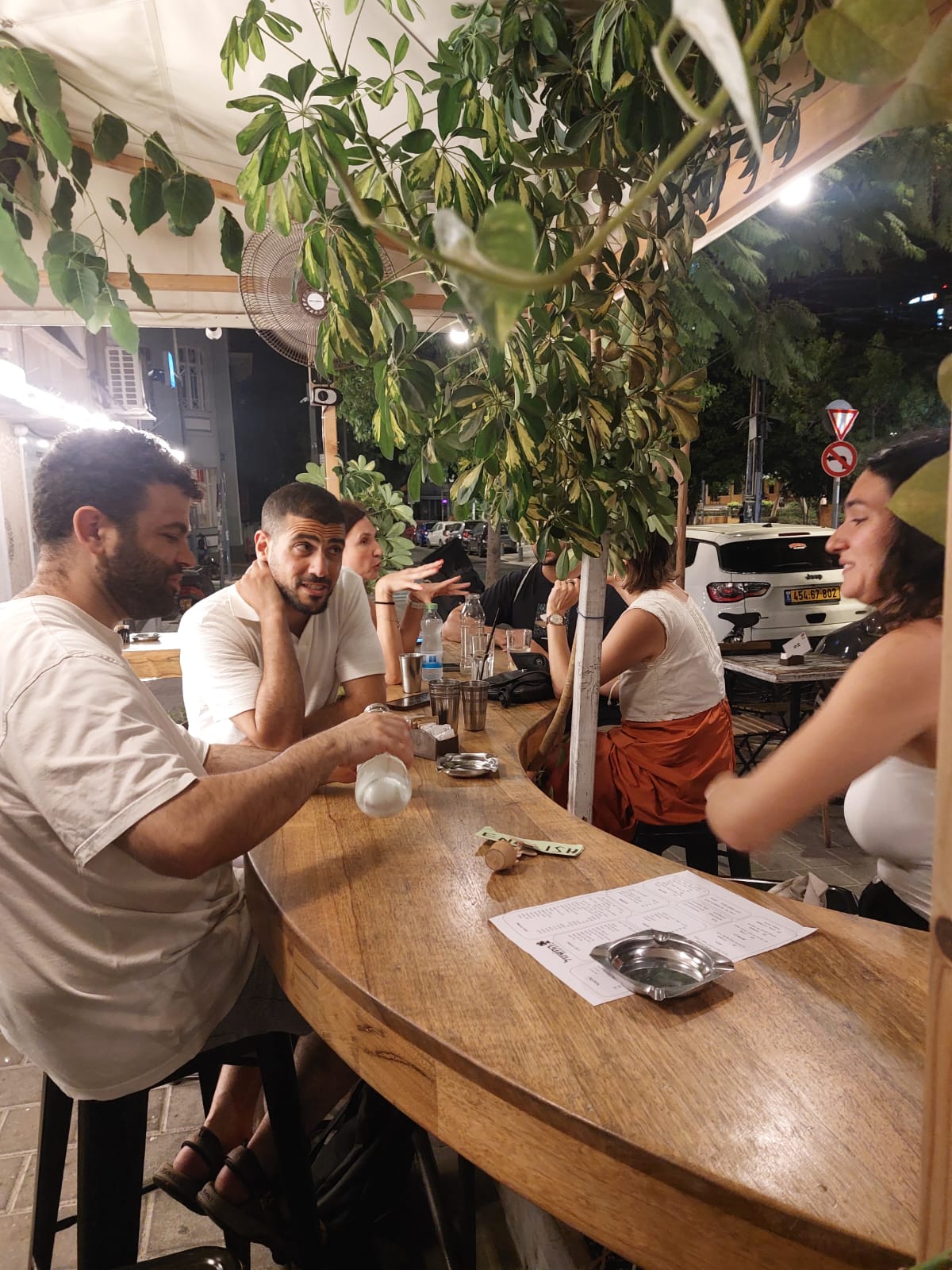 The English language table at Tel-A-Lingo, seated at high stools around a curved wooden bar